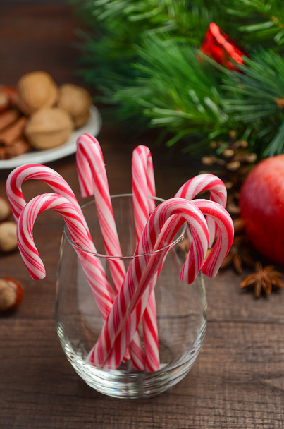 Peppermint Candy Canes and other Christmas decorations on wooden background - Fotografie, Obrázek