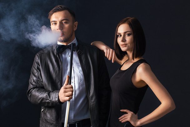 Beautiful couple smoking hookah. Producing the smoke from his mouth. Business style clothing. The pleasure of smoking. Love. - Photo, Image