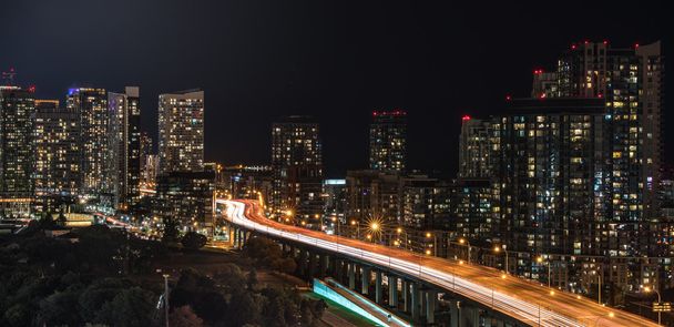 Verlichte stadslandschap van Toronto. Skyline van gebouwen en office torens op een warme en vochtige en regenachtige nacht van augustus in de hoofdstad van Ontario, Canada,   - Foto, afbeelding