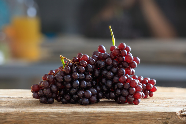 uvas rojas sobre una mesa de madera - Foto, Imagen