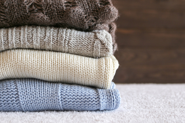 ホームの背景に居心地の良いニットの温かみのあるセーターのスタック。レトロなスタイルのセーター。暖かいのコンセプト . - 写真・画像
