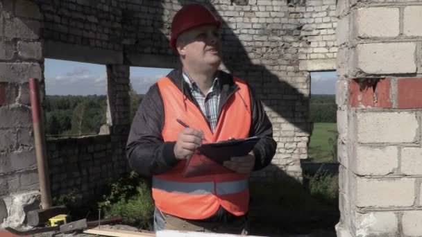 Builder writing and checking building - Materiał filmowy, wideo