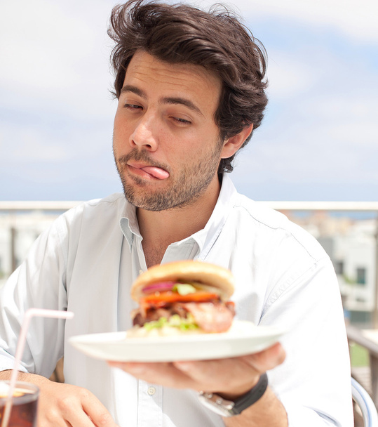 若い男性が、hamburguer を食べて - 写真・画像