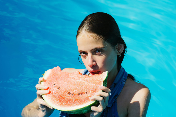 woman with watermelon in swimming pool - 写真・画像