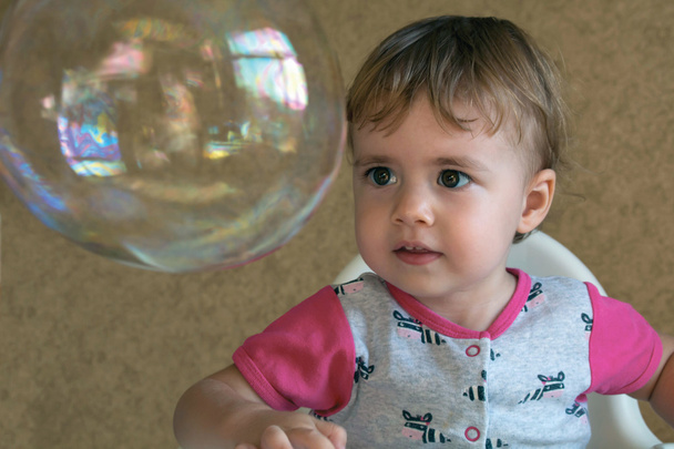 clouse-up retrato menina de dois anos infla uma grande bolha circular
 - Foto, Imagem