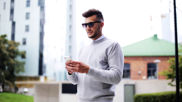 férfi napszemüveg smartphone a város utca - Felvétel, videó