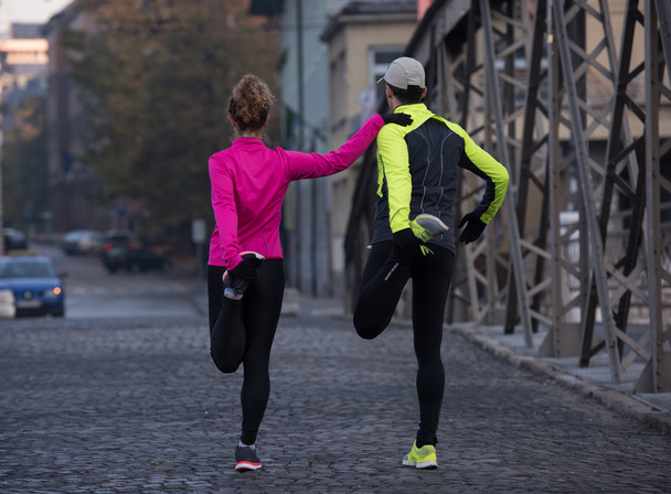 couple warming up before jogging - Foto, afbeelding
