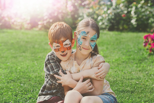 Crianças felizes, menino e menina com pintura facial no parque
 - Foto, Imagem