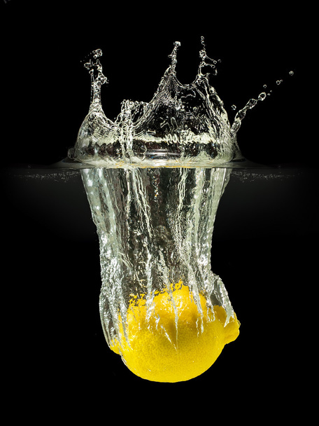 Fresh fruits falling in water with splash on black background - Foto, afbeelding