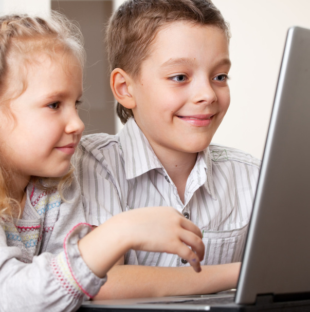 Happy kids playing laptop at home - 写真・画像