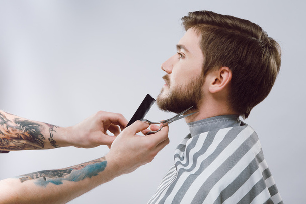 barbero haciendo una forma de barba
 - Foto, imagen