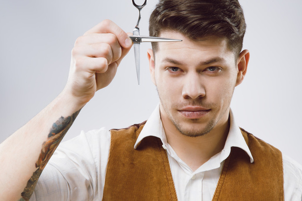 Handsome barber at gray background - Zdjęcie, obraz