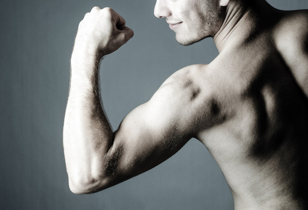 shirtless chlap ukazuje jeho biceps - Fotografie, Obrázek