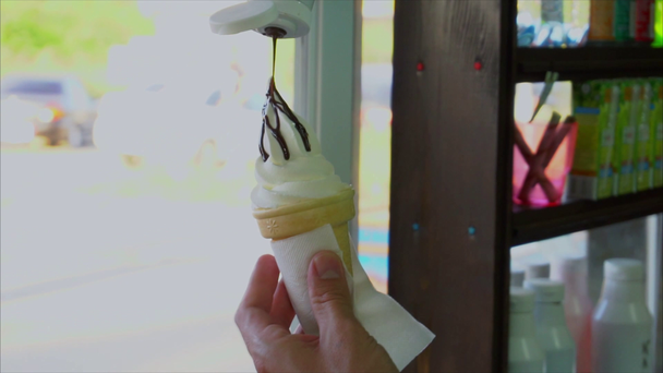 Przekupka, wlewając syrop szyszka czekolada wafel lody - Materiał filmowy, wideo