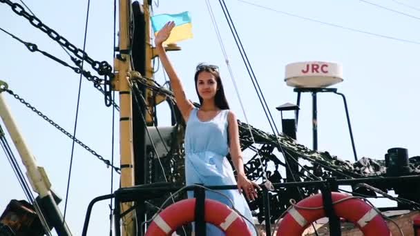 背景に船上の女の子ウクライナの国民色。船上のブルネットの女の子は挨拶で彼の手を振って. - 映像、動画