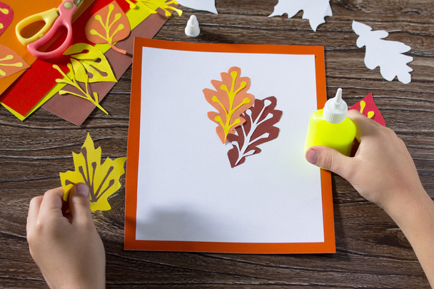 Feuilles d'automne de papier coloré sur un fond en bois. Glu infantile
 - Photo, image
