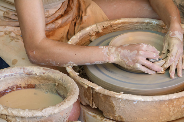 Mani che lavorano sulla ruota della ceramica
 - Foto, immagini