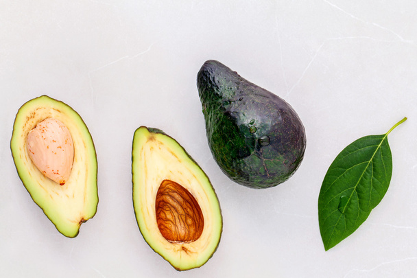 Концепція здорової їжі. Крупним планом свіжий авокадо і листя на мармурі
 - Фото, зображення