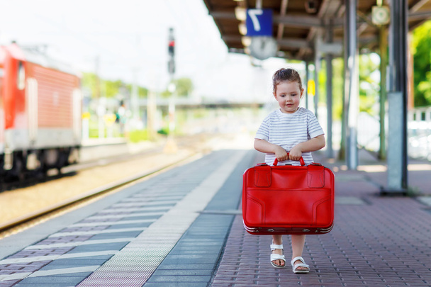 Симпатична маленька дівчинка на вокзалі
. - Фото, зображення