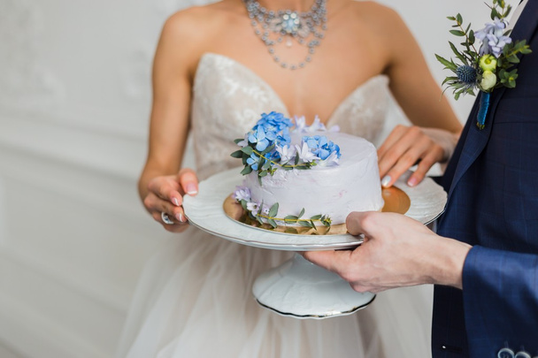 Sposa e sposo tenere torta nuziale
 - Foto, immagini
