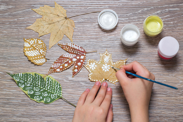 Ragazza dipinge modelli di foglie secche autunno
  - Foto, immagini