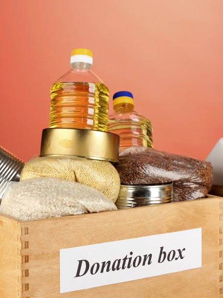 Donation box with food on red background close-up - Fotografie, Obrázek