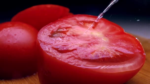 Sprinkling water on cut red tomato. Cold colors. Super slow motion shot - Imágenes, Vídeo