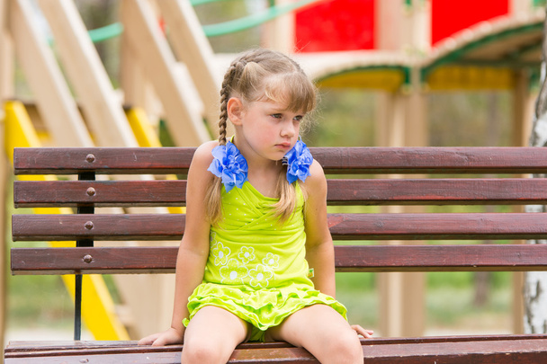 beleidigtes fünfjähriges Mädchen sitzt auf Bank und weint - Foto, Bild
