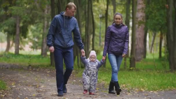 Šťastná rodina: otec, matka a dítě - holčičku v podzimním parku: procházeli uličkou spadaného listí - Záběry, video
