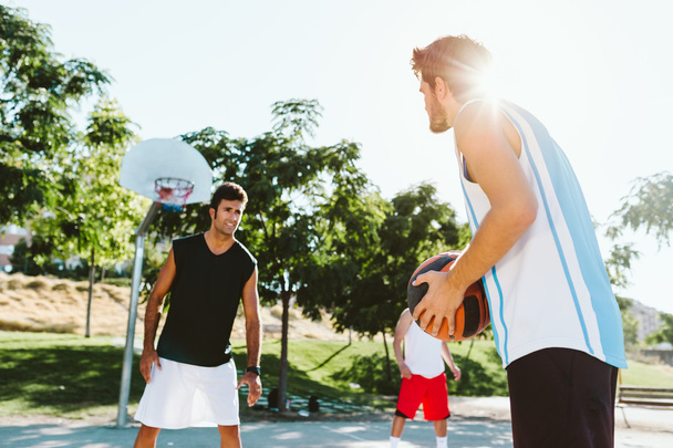 Portrait of group of friends playing basketball on court. - Zdjęcie, obraz