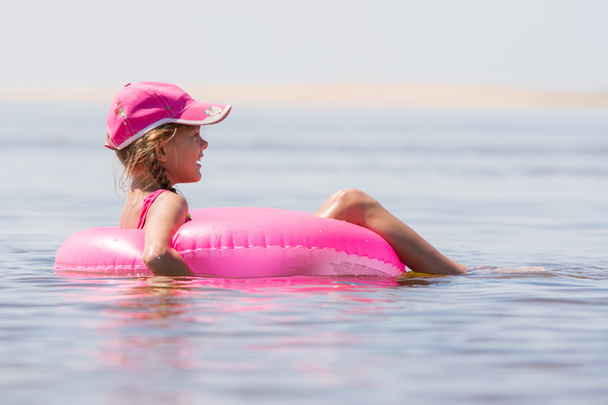 A menina no chapéu nadou no rio sentou-se no círculo de natação
 - Foto, Imagem