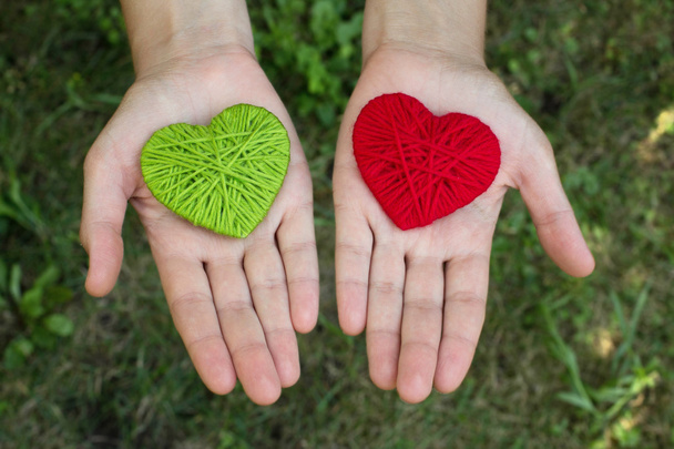 κόκκινο μάλλινο καρδιά σε ένα ανθρώπινο χέρι, ημέρα του Αγίου Βαλεντίνου, αγάπη - Φωτογραφία, εικόνα