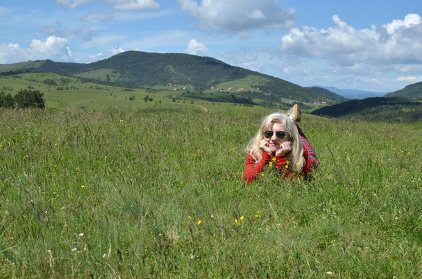 Femme en rouge sur une prairie de montagne
 - Photo, image