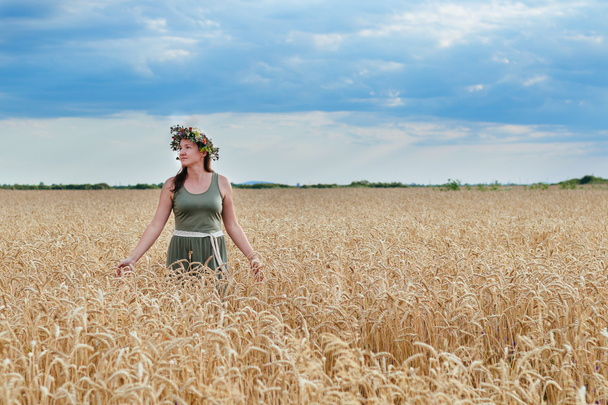 beautiful girl in a wheat field with  wreath on head - Photo, Image