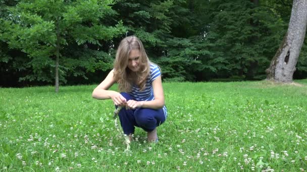 cute woman in blue weave head wreath from clover plant flowers. 4K - Footage, Video