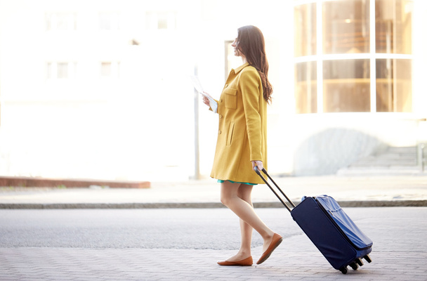 glückliche junge Frau mit Reisetasche und Stadtplan in der Stadt - Foto, Bild
