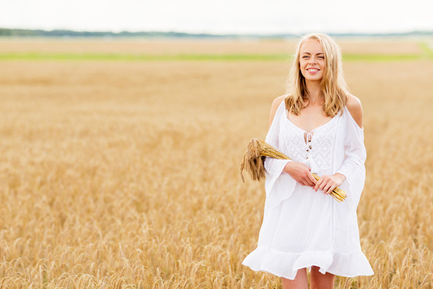 happy young woman with spikelets on cereal field - Photo, image