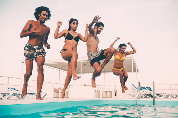 best friends jumping into swimming pool - Photo, Image
