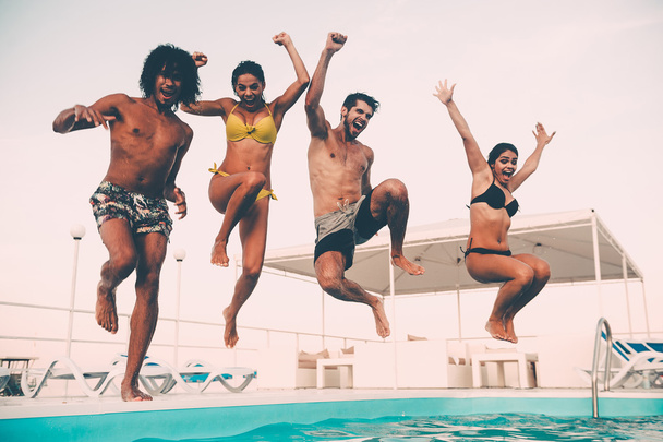 best friends jumping into swimming pool - Photo, image