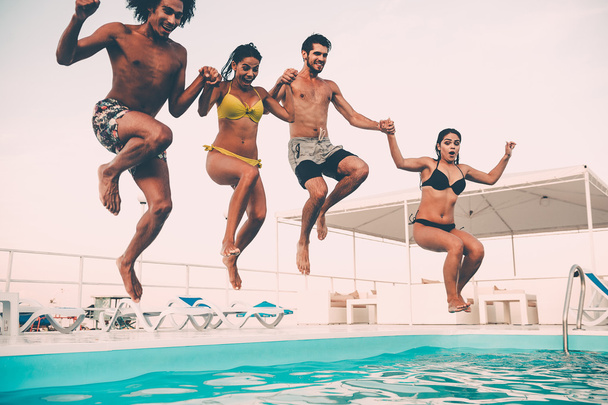 best friends jumping into swimming pool - Foto, afbeelding