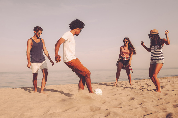 best friends playing beach football - Foto, afbeelding