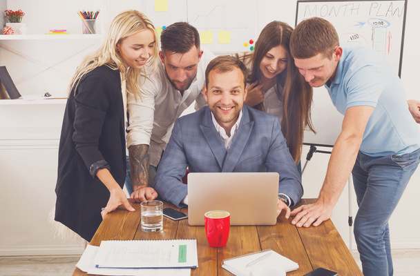 Équipe de gens d'affaires heureux avec ordinateur portable dans le bureau
 - Photo, image