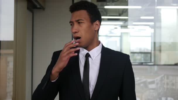 Empresario negro cansado bostezando en traje, interior
 - Metraje, vídeo