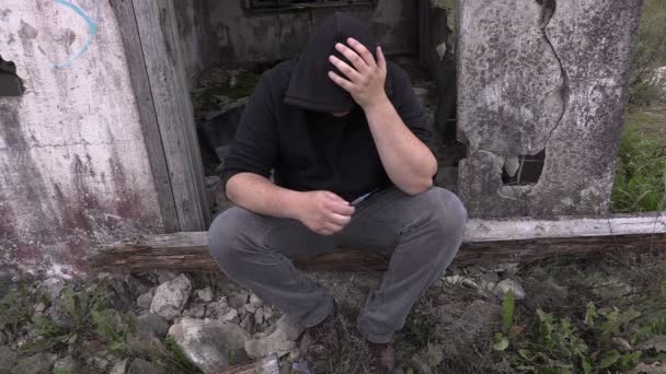 Drogenabhängiger Mann mit Spritze nahe verlassenem Gebäude - Filmmaterial, Video