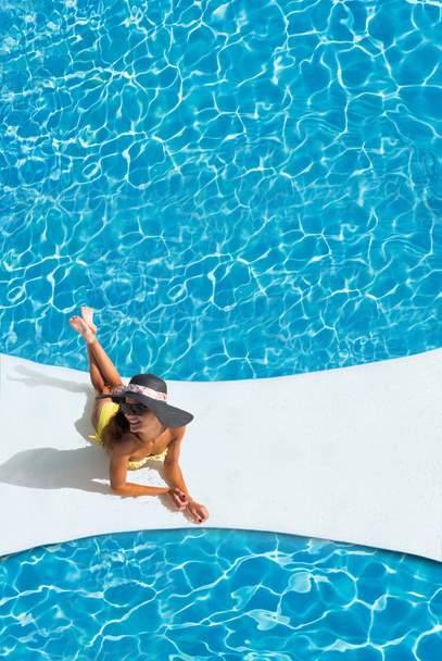 güzel tabaklanmış sportif ince kadın rahatlatıcı yüzme havuzunda  - Fotoğraf, Görsel