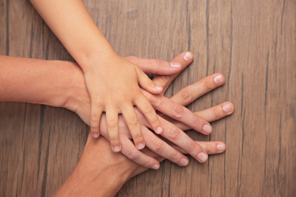 Family hands on wooden background - Photo, image