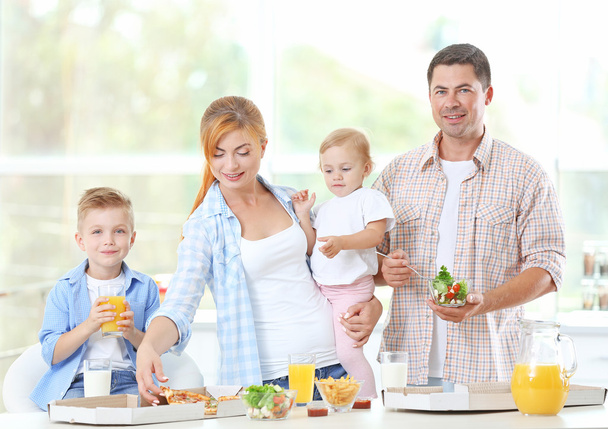 Happy family eating pizza in kitchen - Foto, Imagen