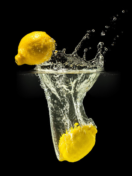 Group of fresh fruits falling in water with splash on black background - Foto, Bild