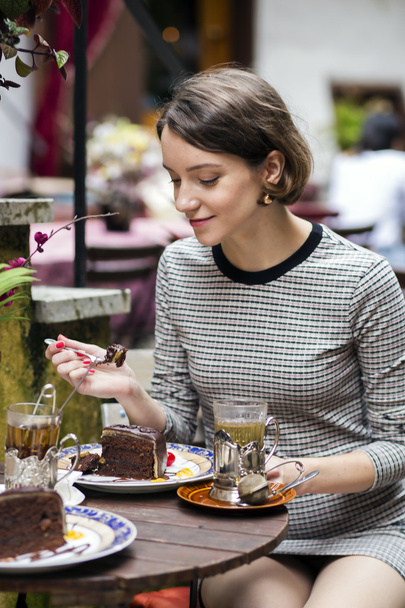 Femme à la robe au café goûter le gâteau
 - Photo, image