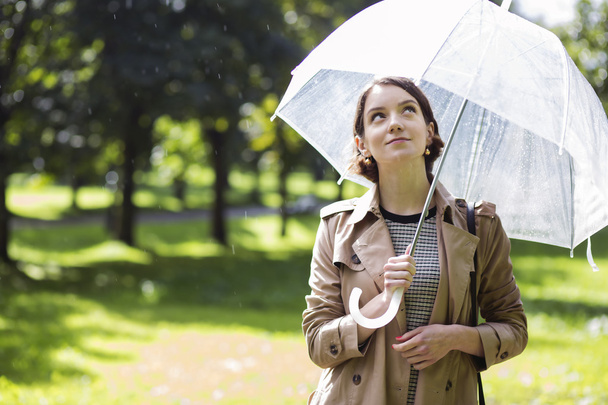 Mujer en abrigo beige y gotas de lluvia lloviznante
 - Foto, imagen
